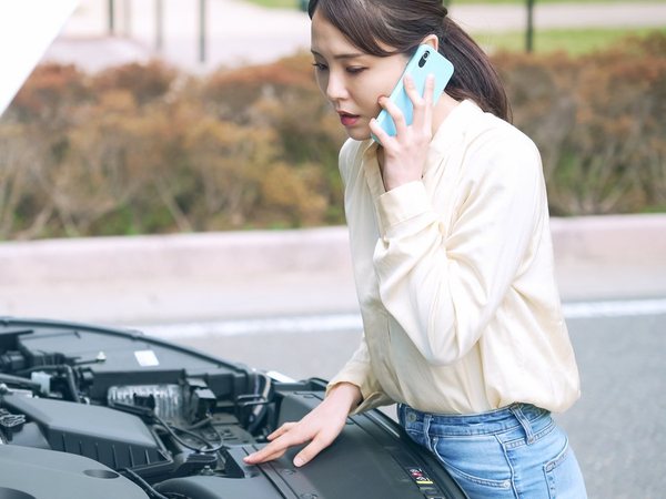 車の故障で電話をかける女性(イメージ)